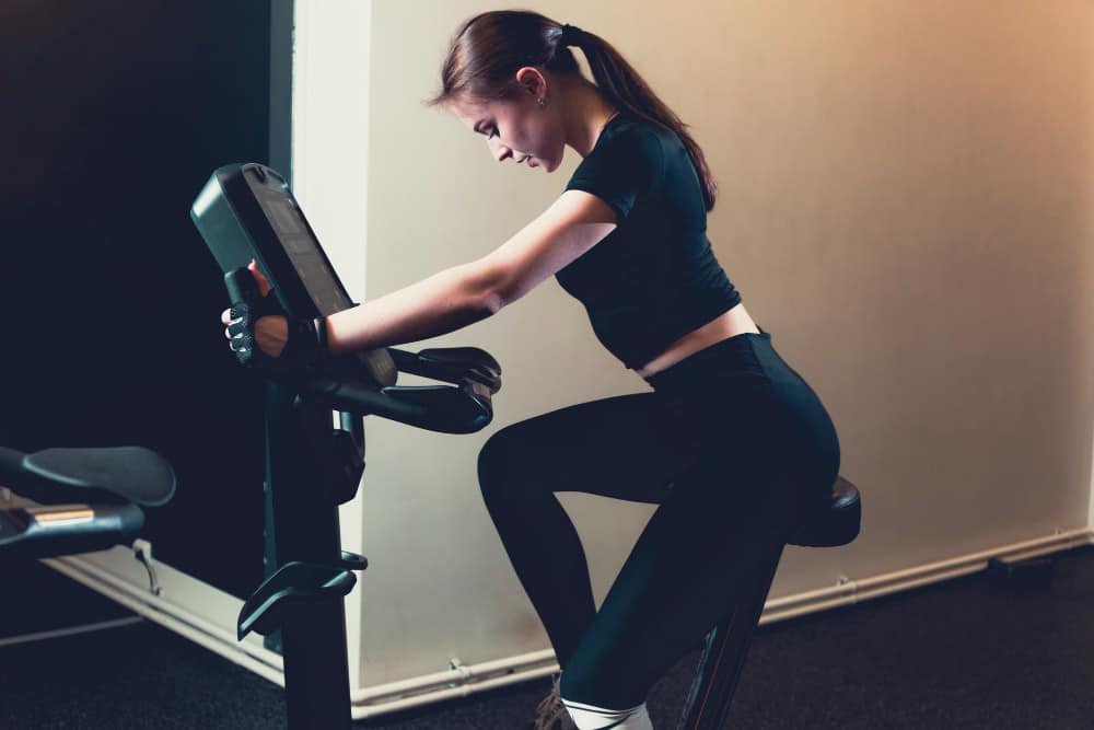 comment choisir un vélo d'appartement : une femme fait du vélo d'appartement