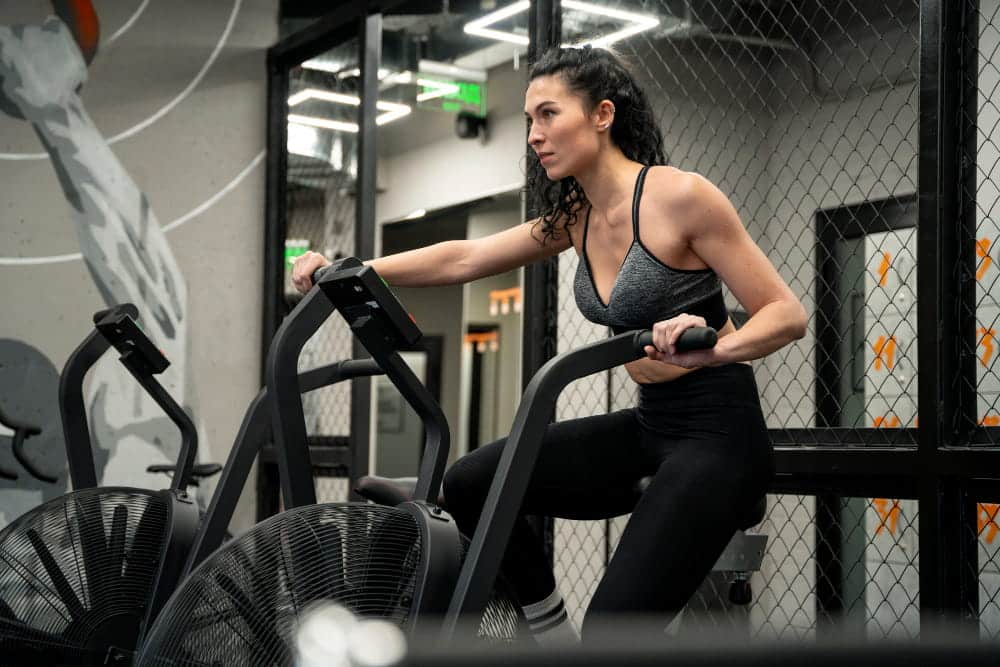 Différent type de vélo salle de sport : une femme fait du vélo en salle