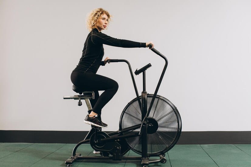 Mal de dos et velo d'appartement : une femme pratique du vélo d'appartement