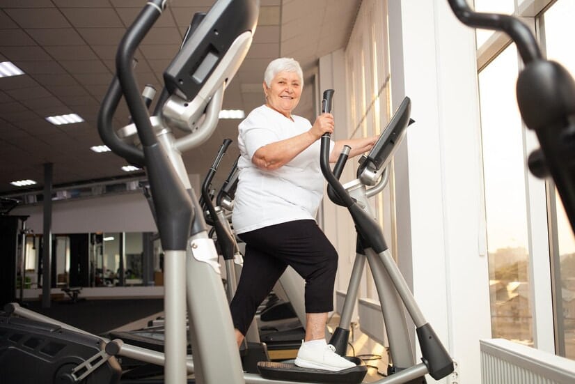 Programme vélo elliptique senior : une femme sénior fait du vélo elliptique