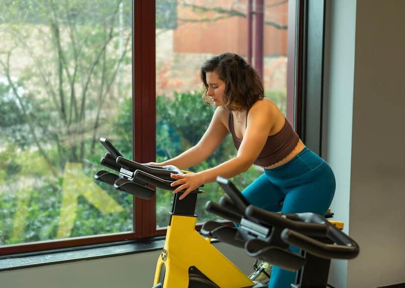 Une femme monte sur un vélo d'appartement