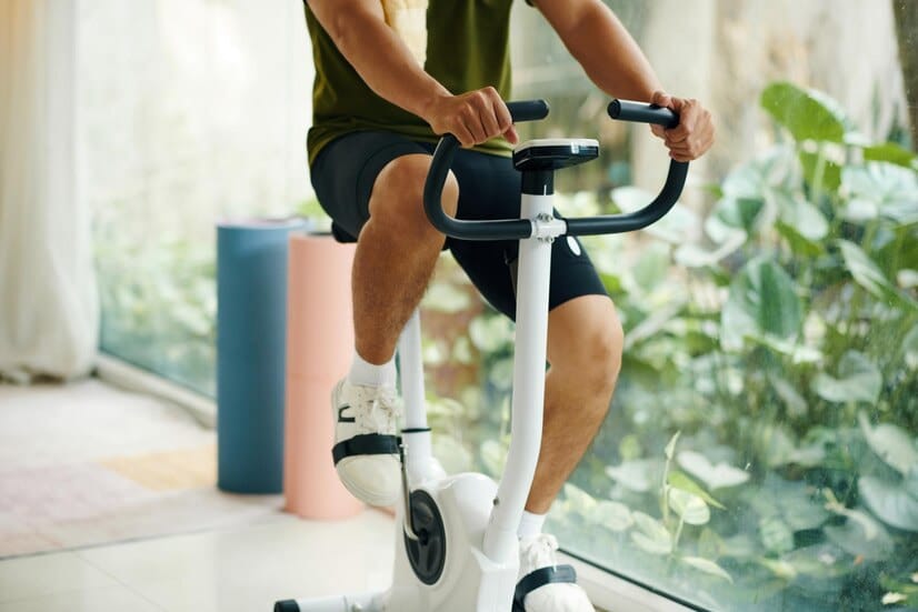 Zone fréquence cardiaque vélo : Un homme fait du vélo d'appartement